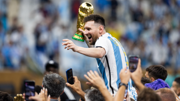 Lionel Messi celebrates with the 2022 World Cup trophy